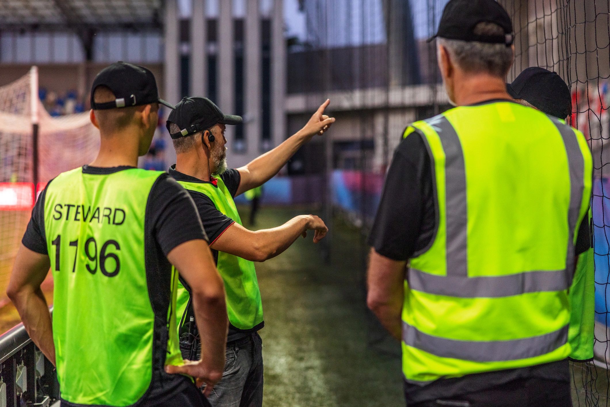 Soccer field security guards in reflective vests talking